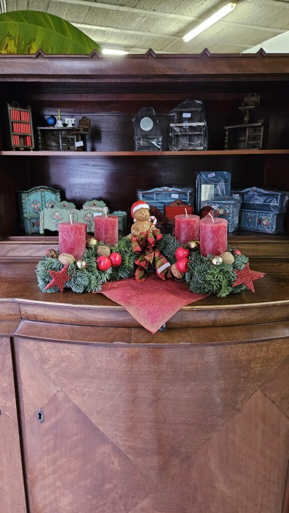 Ein Adventskranz steht auf einem alten Schrank.